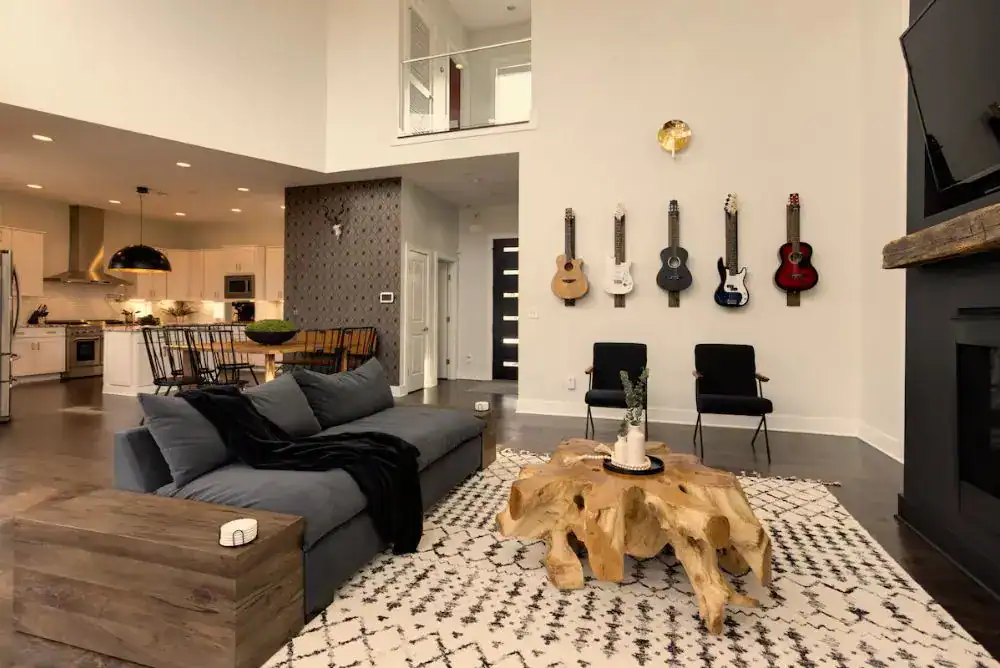 Cozy living room in a Nashville TN rental with guitars on the wall and comfortable seating. Perfect for your stay when you travel to Nashville.