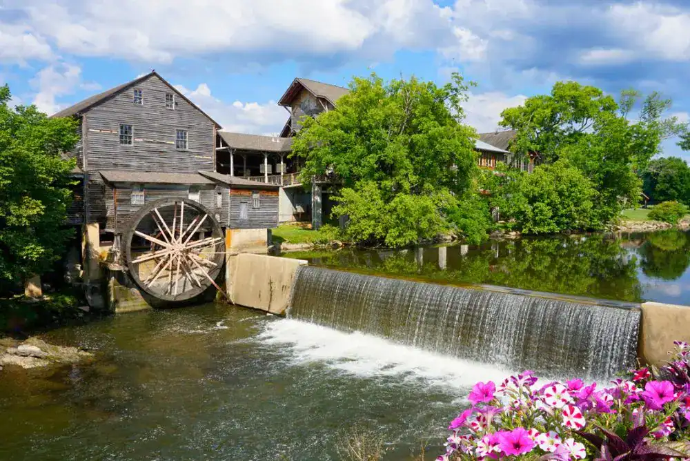 Old Mill in Pigeon Forge TN in spring with waterfall and blooming flowers