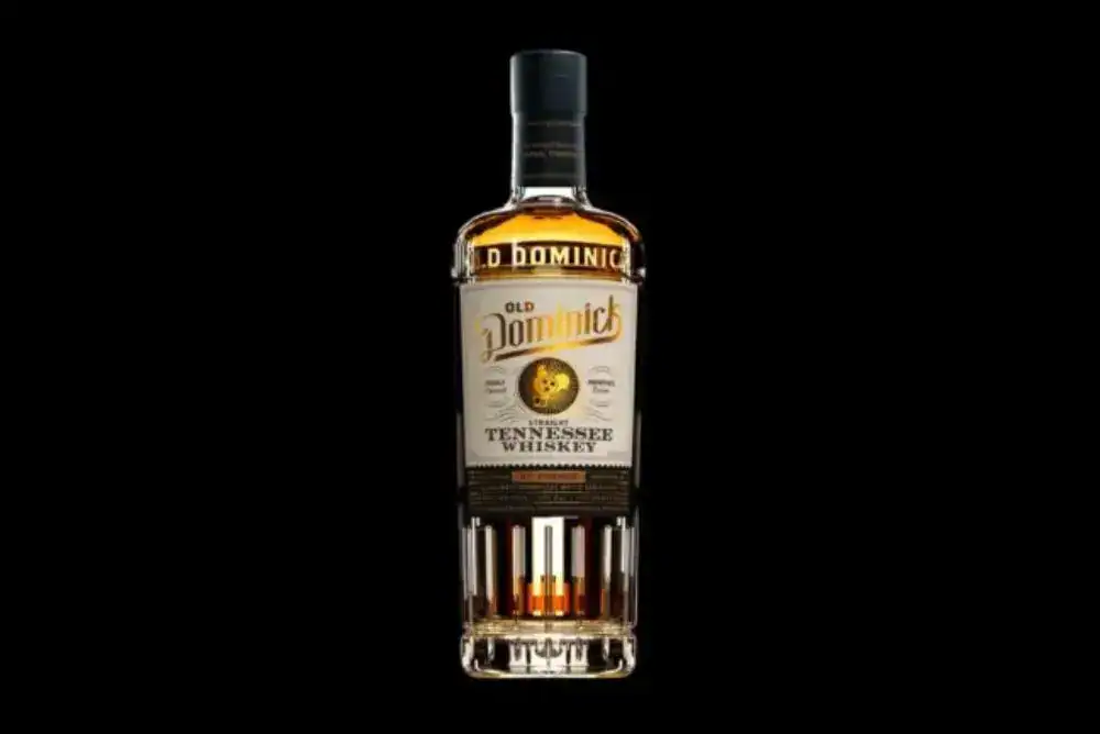 Old Dominick bottle of spirits on black background