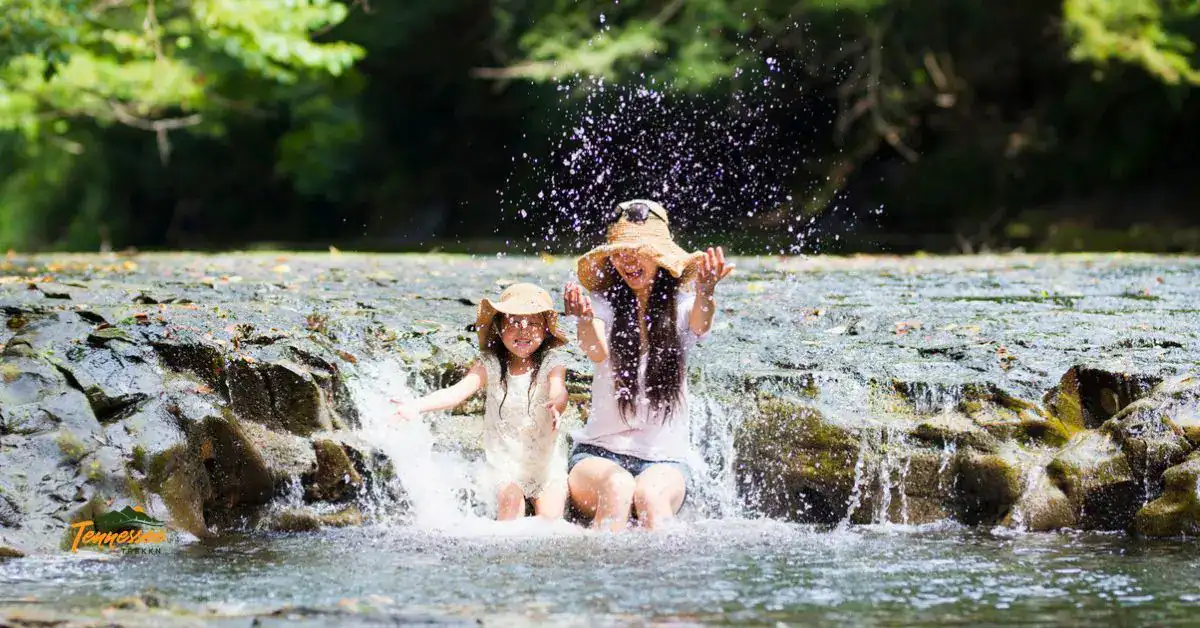 Kid-friendly destinations in Tennessee — mom and daughter splashing in a Smoky Mountain creek