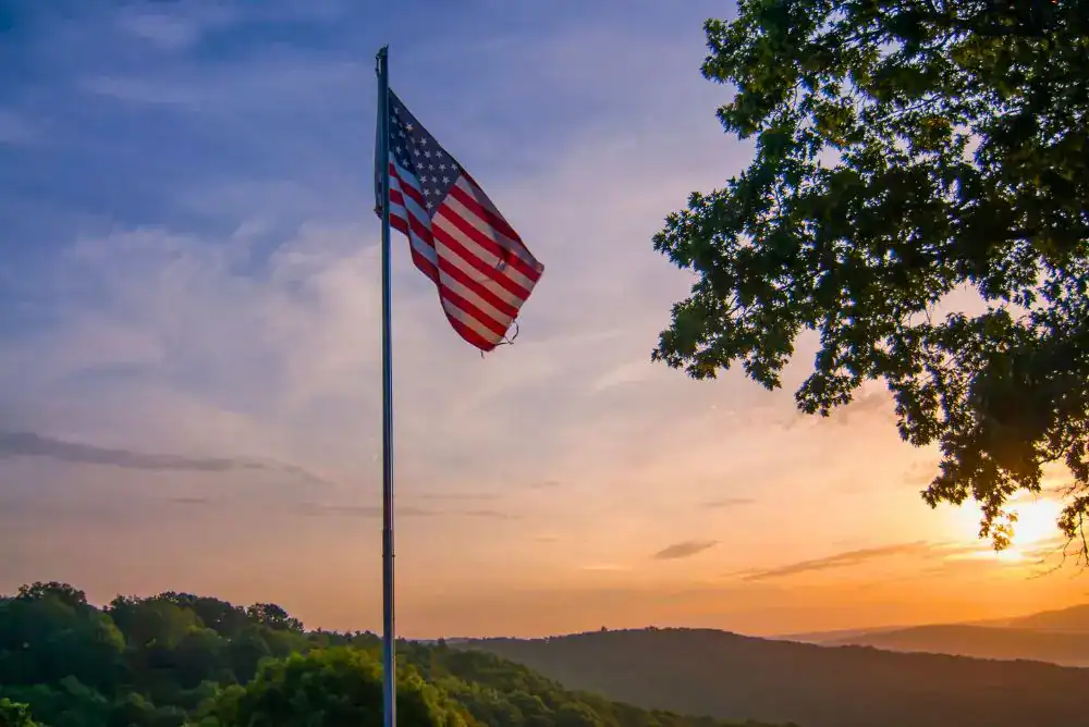 American flag flying at sunset during a Fourth of July celebration, honoring the service and sacrifice of military families.