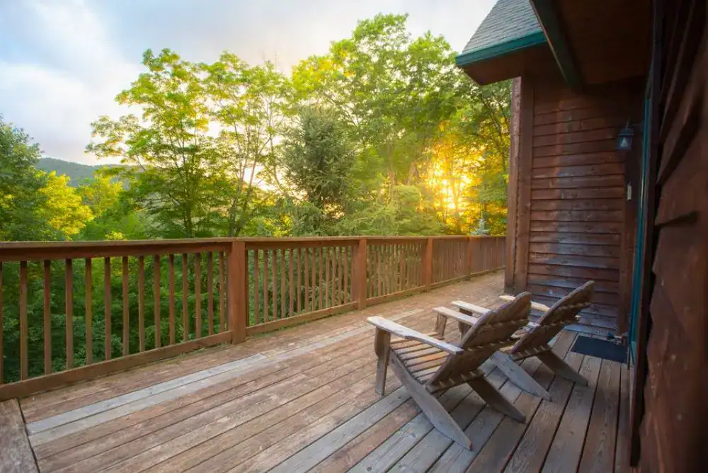 Two Adirondack chairs on a cabin deck overlooking the mountains, one of many places to stay in Tennessee