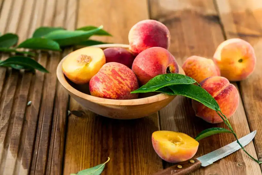 bowl of fresh peaches - perfect for an added touch to this Smoky Mountain Sunset whiskey cocktail recipe