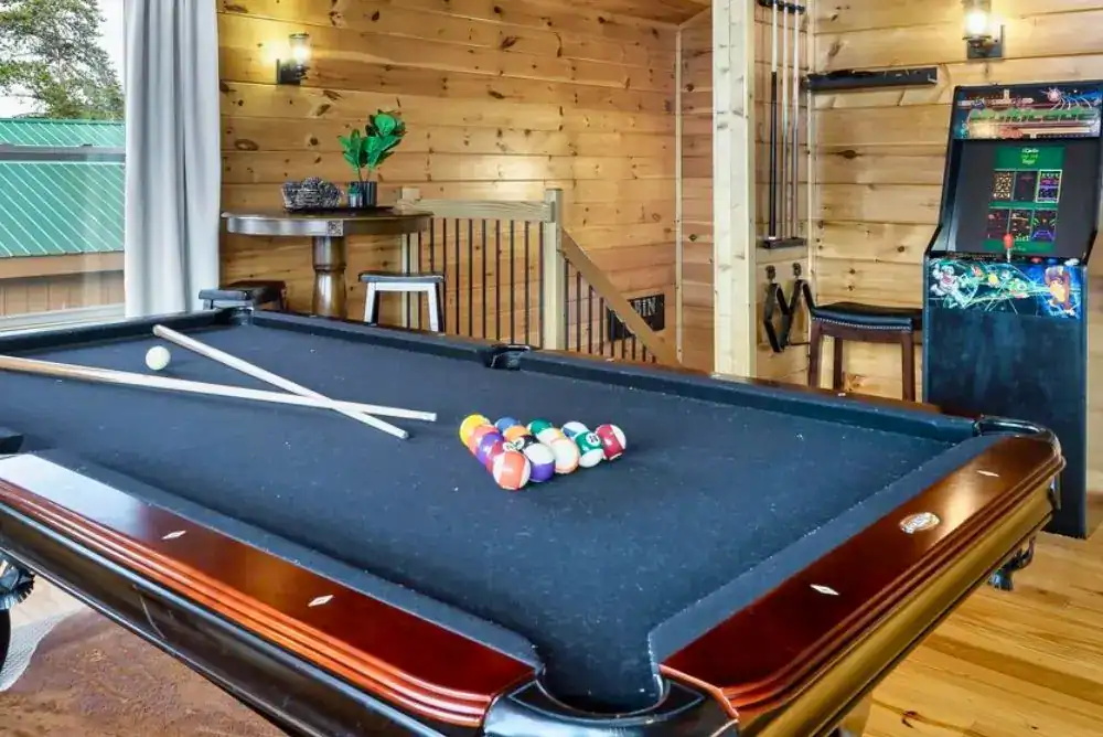 Game room with a pool table and arcade in one of the Pigeon Forge cabins for families