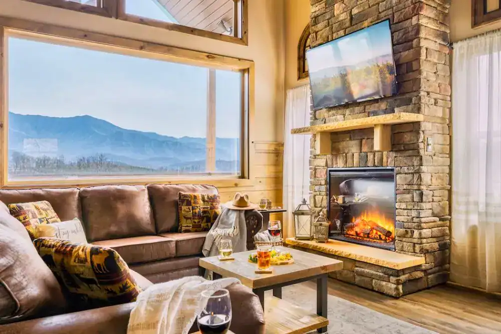 Cabin living room with fireplace and mountain views
