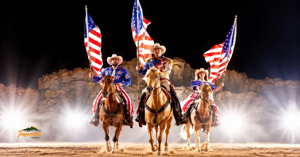 Riders on horseback carrying American flags during Dolly Parton's Stampede in Pigeon Forge, Tennessee.