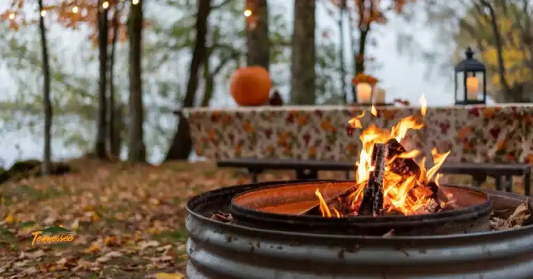 Cozy fall campsite with a campfire and colorful leaves, perfect for a fall camping trip.