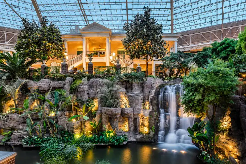 Indoor waterfall surrounded by tropical plants inside the Gaylord Opryland Resort atrium in Nashville.
